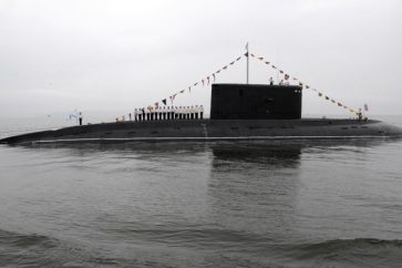 The crew of a Russian Kilo-class diesel submarine line up on its deck during a naval parade rehearsal at Vladivostok's harbour