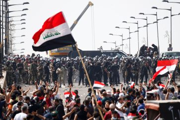 Iraqi security forces stand in front of demonstrators during a protest over corruption, lack of jobs, and poor services, in Baghdad, Iraq October 25, 2019. REUTERS/Thaier Al-Sudani     TPX IMAGES OF THE DAY