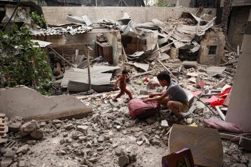 A Palestinian child salvages objects amid the debris of a house destroyed by overnight Israeli bombardment in Rafah in the southern Gaza Strip on April 27, 2024, as the conflict between Israel and the militant group Hamas continues. (Photo by AFP)