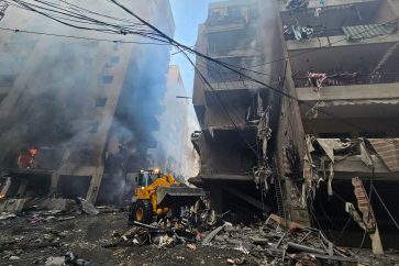 An excavator clears rubble in front of buildings hit an Israeli airstrike that targeted the neighbourhood of Haret Hreik in Beirut's southern suburbs on November 21, 2024, amid the ongoing war between Israel and Hezbollah. (Photo by AFP)